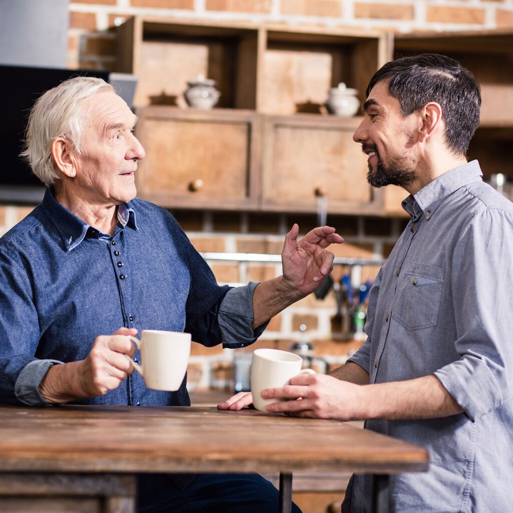 Nur reden. Zwei ältere Männer unterhalten sich, während Sie einen Kaffee in der Küche trinken.